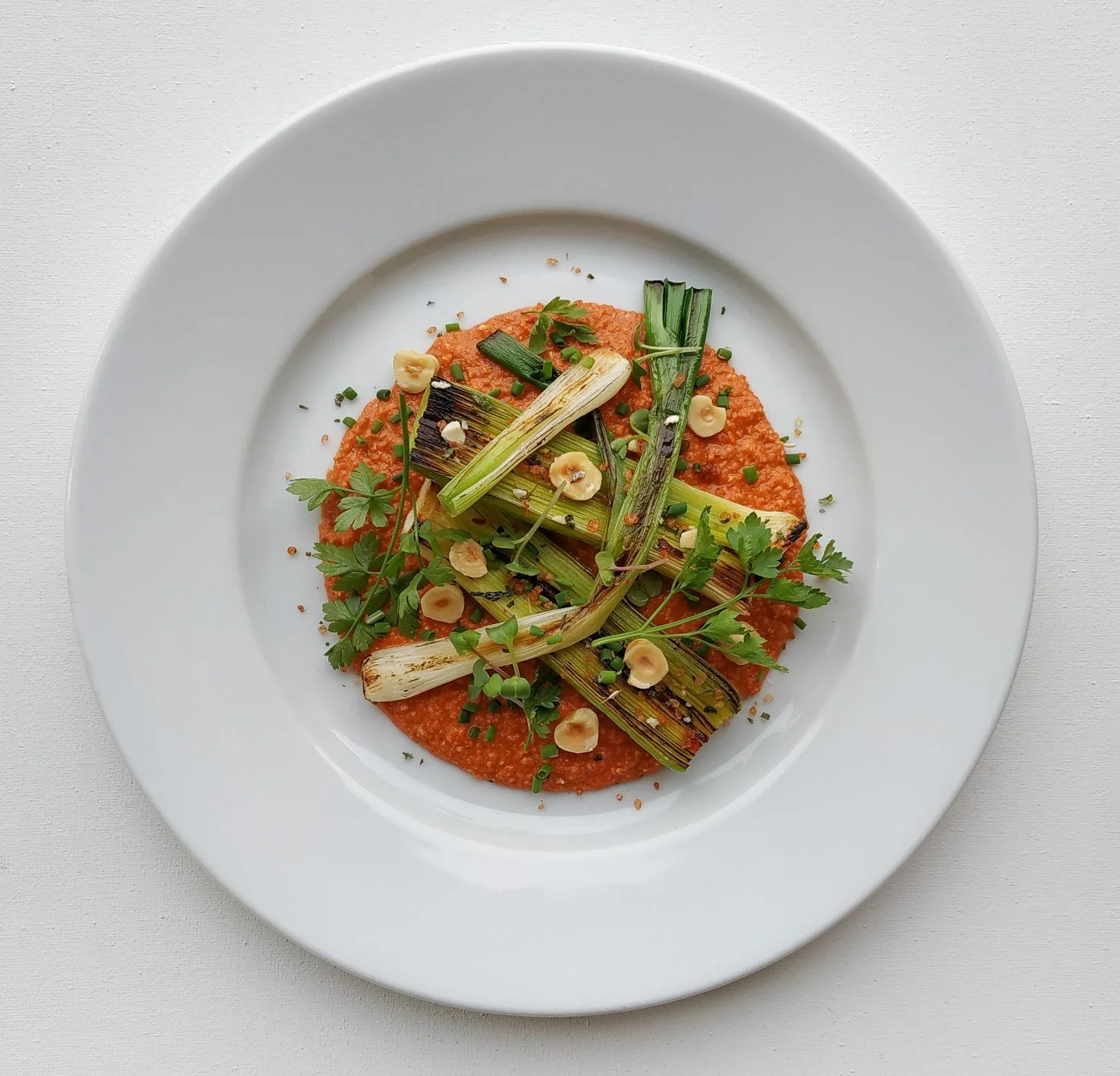 Fried leeks with Romesco sauce and hazelnuts
